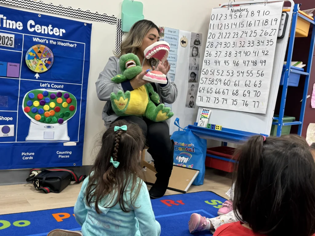 A teacher using an alligator puppet for an interactive circle time lesson in the GMCC classroom
