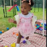 A toddler celebrating with colorful toys and bubbles during a birthday event at GMCC